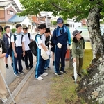 県自然保護協会の山崎紫副理事長（右）から、クビアカツヤカミキリの痕跡を探す方法について解説を聞く高校生ら＝三田市下相野