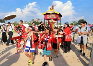 みこしを元気よく担いで運動場を練り歩く子どもら＝三田市弥生が丘２