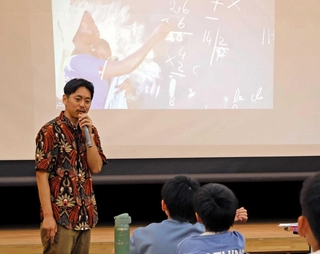 世界の教育現場について話す岡本啓史さん＝三田市けやき台１