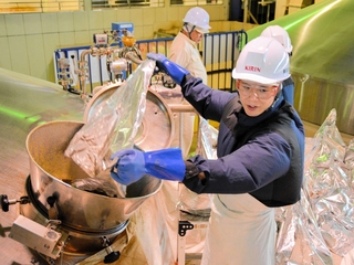 次々とホップを投入していく従業員ら＝神戸市北区赤松台２