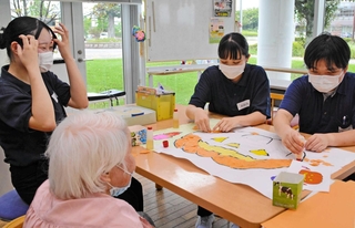 デイサービス利用者と作業しながら交流を深めた学生ら＝三田市川除
