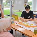 デイサービス利用者と作業しながら交流を深めた学生ら＝三田市川除