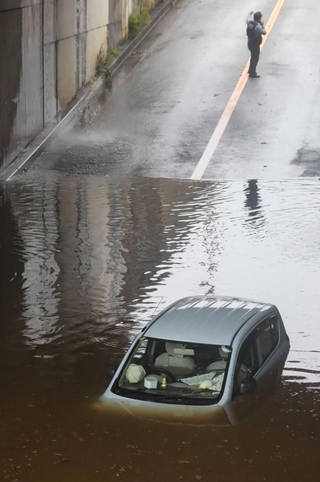 ７月８日の豪雨で冠水したアンダーパス。乗用車が立ち往生した＝三田市川除