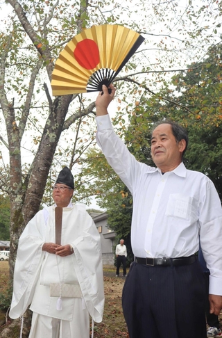 末西天満神社に向かって扇を掲げる吉谷政洋区長＝三田市末