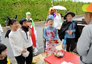 家々を訪ね、出迎えた住人に「トリック・オア・トリート」と声を上げる子どもら＝三田市すずかけ台