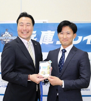 阪神スカウトの筒井和也さんから、記念品としてドラフト会議のＩＤパスを受け取った山崎照英選手（右）＝兵庫県三田市天神１