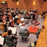 合同演奏会に向けて練習する管弦合奏団と三田少年少女合唱団のメンバーら＝三田市武庫が丘７