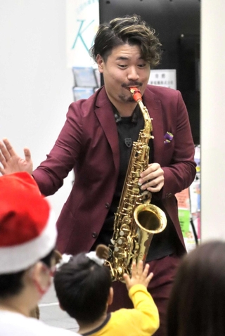 市役所本庁舎で行われたクリスマスコンサート。三田市出身のサックス奏者、新井貴之さんらが会場を盛り上げた＝三田市三輪２