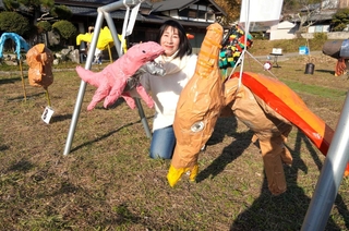 子どもたちが作った個性豊かな恐竜のかかしを紹介する唯文砂子さん＝三田市小野