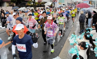 沿道から声援を浴びながら、元気にスタートを切るランナーたち＝三田市天神