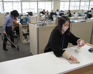 カウンターを拭き、掃除機をかける職員たち＝三田市役所