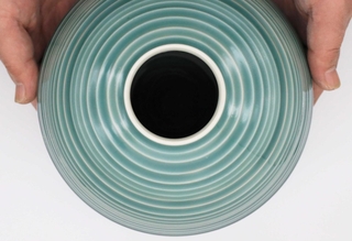 透明感のある碧色が特徴の三田青磁。表面に凹凸がある花瓶は、釉薬（ゆうやく）の厚みによって色合いが変化する＝三田市四ツ辻