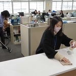 カウンターを拭き、掃除機をかける職員たち＝三田市役所