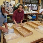 和田良三道場長（中央）の指導を受けながらそば打ちに取り組む岩倉そばの会のメンバー＝三田市永沢寺