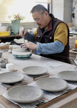 三田青磁の伝統ともいえる型を使って成形する伊藤瑞宝さん＝三田市四ツ辻