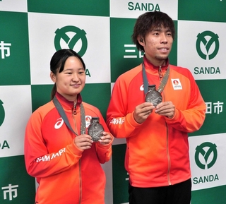銀メダルを手にする杉本大地さん（右）と石岡洸菜さん＝三田市役所