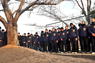 藤田伸哉さんを悼み、桜の木の前で黙とうする野球部員たち＝三田市南が丘２