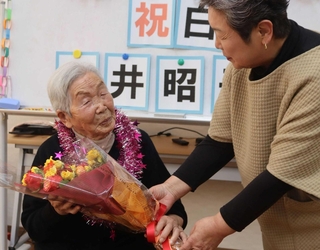 誕生日を１カ月後に控え、花束を贈られる亀井昭子さん＝三田市沢谷