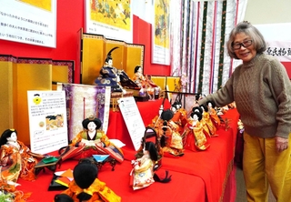 源氏物語から読み取れる伝統行事を再現したひな飾りの説明をする松生昭子さん＝三田ふるさと学習館