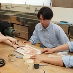 愛和義肢製作所の義肢装具士（左）に教わりながら、肌の色を再現する学生ら＝三田市福島