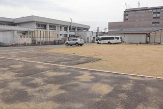 新しい給食センターの整備予定地。現在は駐車場などとして使われている＝三田市ゆりのき台６