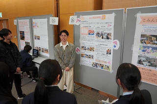 パネル前に集まった人たちに取り組みを説明する学生＝三田市けやき台１