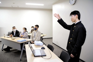 三田市職員に向け、植物発電の取り組みを説明する高谷譲さん（右）＝三田市三輪２