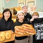 消防車の焼き印入りのパンや、オリジナルＴシャツを手にするモリタホールディングス社員とサンポッポベーカリーのスタッフら＝三田市三輪１