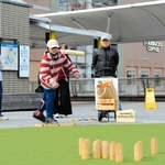 モルックを投げる菖蒲十馬さん（左から３人目）。地域住民との輪も自然と広がる＝三田市駅前町