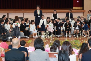 入学を祝う会に出席した児童ら。保護者が名前や特技を順番に紹介した＝猪名川町笹尾