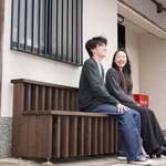 三田本町通りセンター街の一角に設置したベンチに座る的場陽斗さん（左）と工藤泉希さん＝三田市三田町