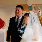 夫の横山康隆さん（左）と並び、涙ぐむ千夏さん。病院スタッフの補助で、立つことができた＝三田市大原（提供）