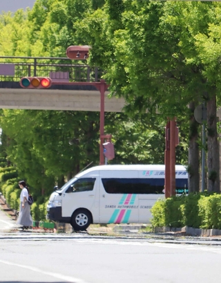 １９日午後、熱せられた路上に出現した「逃げ水」＝三田市けやき台３