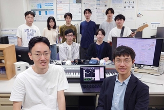片寄研究室のメンバー。手前左が沖田陽一さん、右が川口竜斉さん。研究室には楽器が並ぶ（提供）