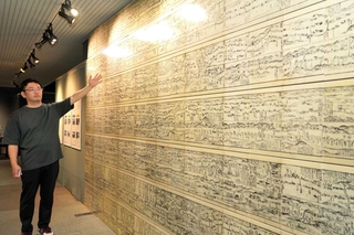 「まちのウラオモテ」として展示する「木曽東海両道中懐宝図鑑」の説明をする福本優研究員＝三田市弥生が丘６