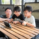 福本優研究員（左）と交流しながらゲームを楽しむ子どもたち＝三田市弥生が丘６