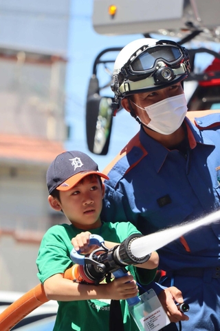 隊員とともにホースで放水する子ども＝三田市下深田