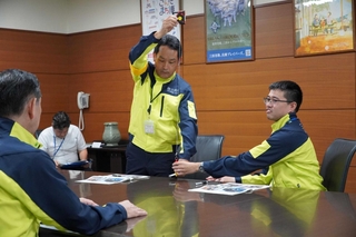熊本県での家屋調査の方法を示しながら、支援活動を報告する嶋利知也さん（右）と萩原律さん＝三田市役所