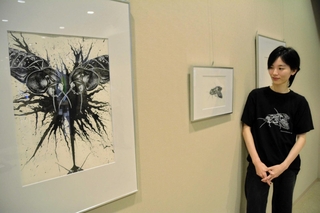 クチキゴキブリを描いた細密画を前にする大崎遥花研究員＝三田市弥生が丘６