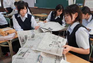 新聞を広げ、興味のある記事を探す生徒たち＝三田祥雲館高校