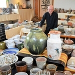 多くの有馬富士焼作品と定金忠孝さん＝三田市下井沢