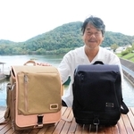 ランドセルを紹介する冨士松大智社長。千丈寺湖のほとりの本社にはショップとカフェも併設している＝三田市末