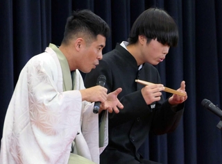 記念式典で生徒に落語のさまざまな動きを教えたＯＢの桂三語さん（提供）