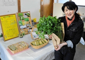 三つ葉を手にする鍋島晴美さんとケーキなどの加工品＝赤穂市中広
