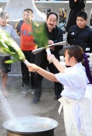 秋祭りの様子を楽しげにスケッチする松井守男さん（奥中央）。島民の輪にあっという間にとけ込んだ＝昨年１１月、姫路市家島町真浦