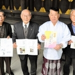 完成した本を手にする赤穂山鹿素行研究会の飯尾義明会長（右から２人目）ら＝赤穂大石神社内の山鹿神社