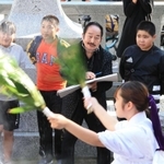 秋祭りの様子を楽しげにスケッチする松井守男さん（奥中央）。島民の輪にあっという間にとけ込んだ＝昨年１１月、姫路市家島町真浦