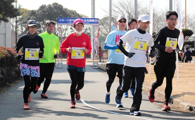 スマートフォンを携帯して、オープニングイベントで走る参加者ら＝赤穂城南緑地運動公園
