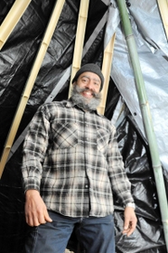 竹を組んで作ったテントとジオバニ・モントージャさん＝赤穂市御崎