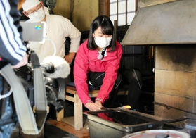 テレビロケで鍛刀場を訪れた相生みなとの女王の後藤真由さん（右）＝相生市矢野町瓜生、羅漢の里